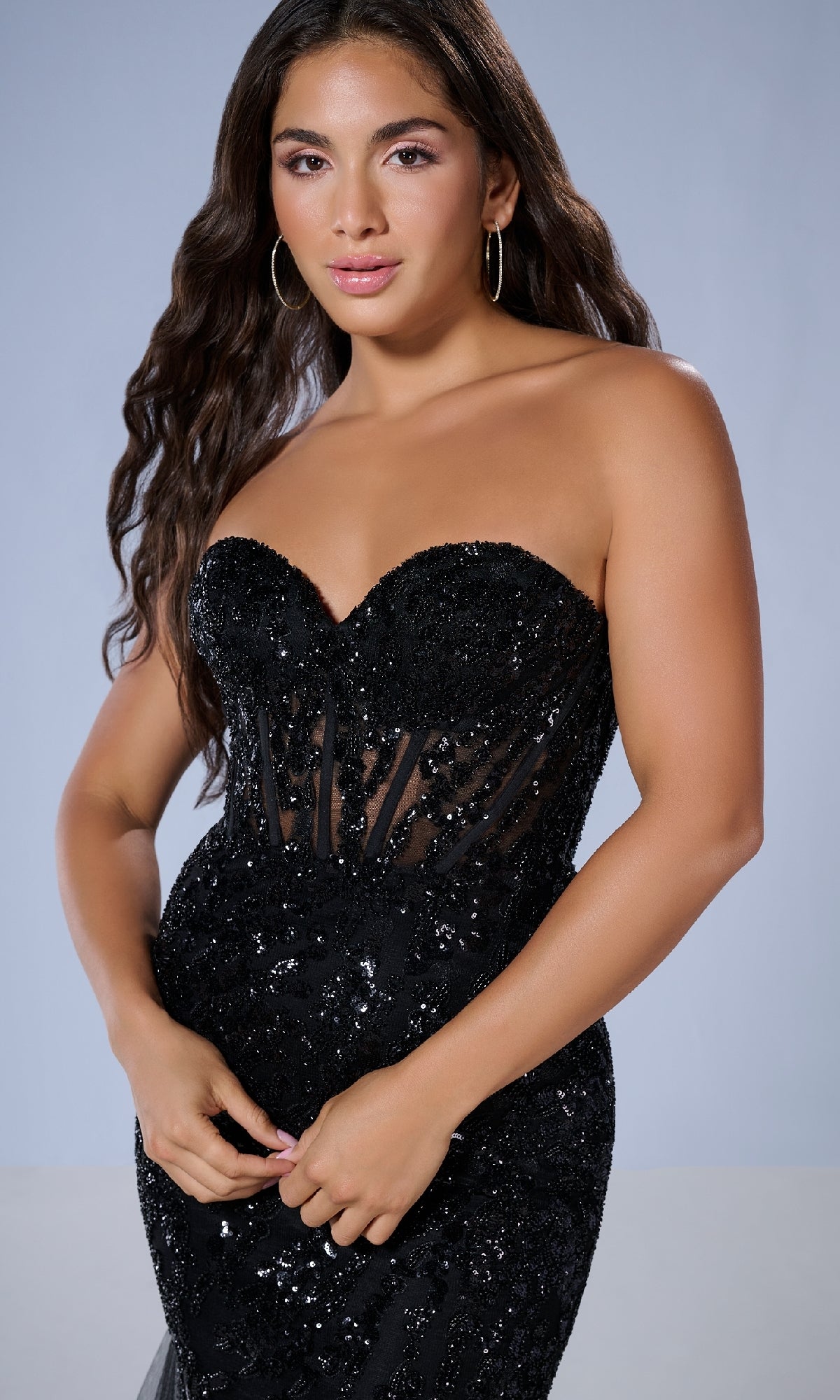 A woman models the Long Prom Dress: Tiffany 16170—a strapless mermaid gown with a sweetheart neckline, black sequins, and sheer panel details—standing against a plain light background.
